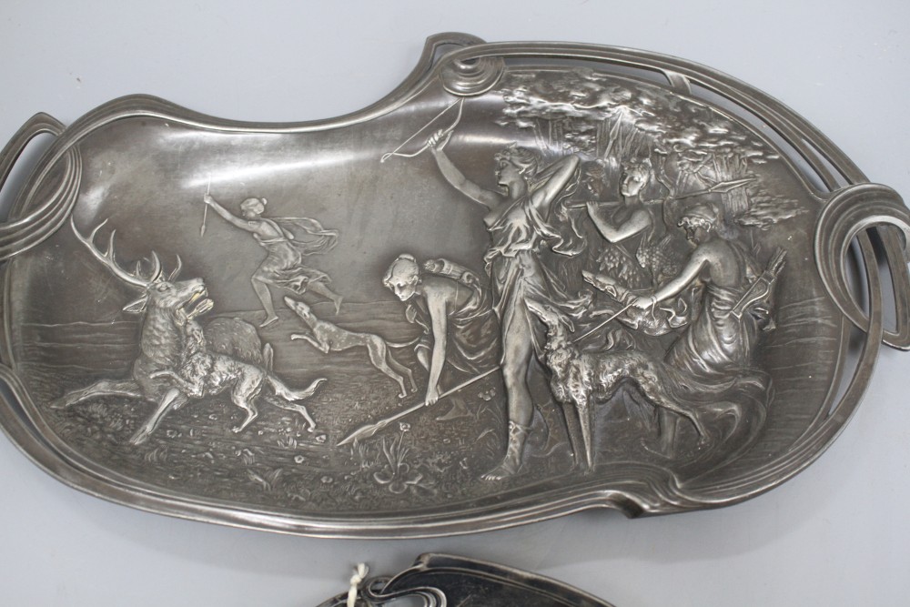 A WMF pewter tray, decorated with two maidens, 23cm, and another tray decorated with Diana hunting a stag, 41cm
